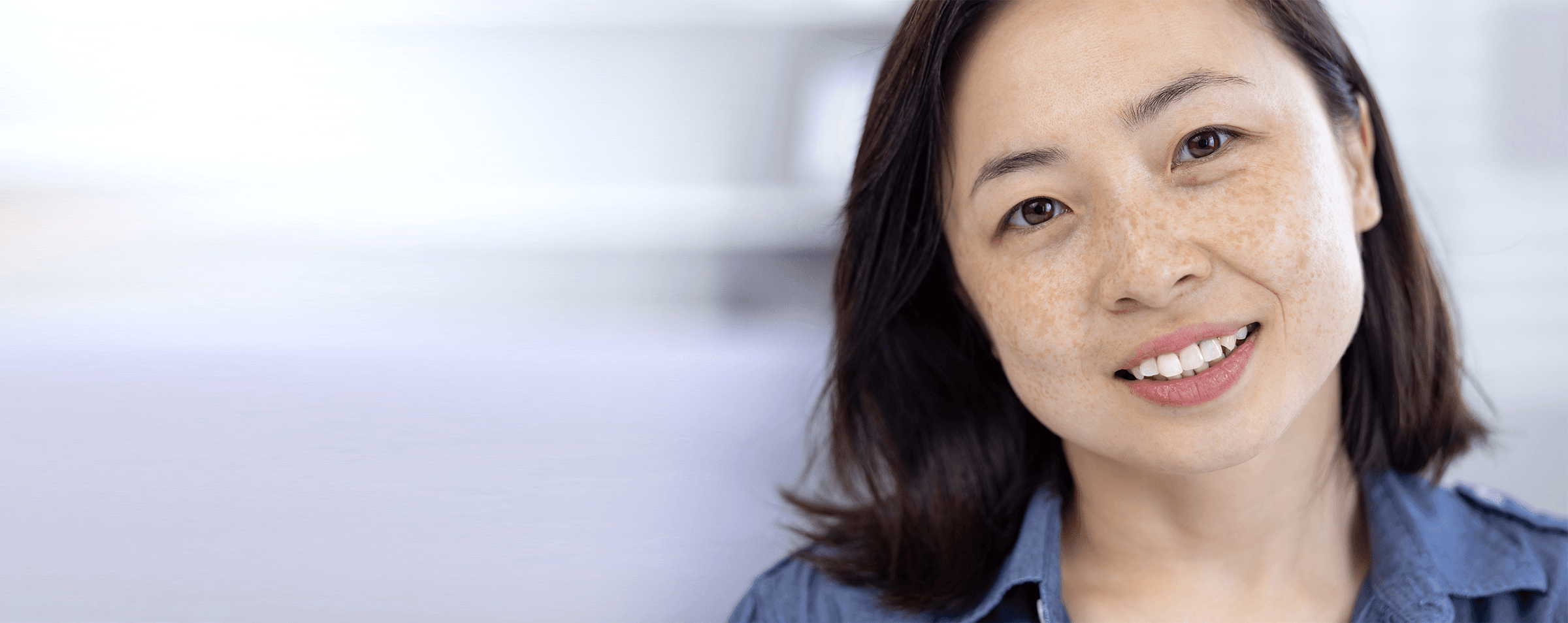 Eye through torn paper on yellow background.