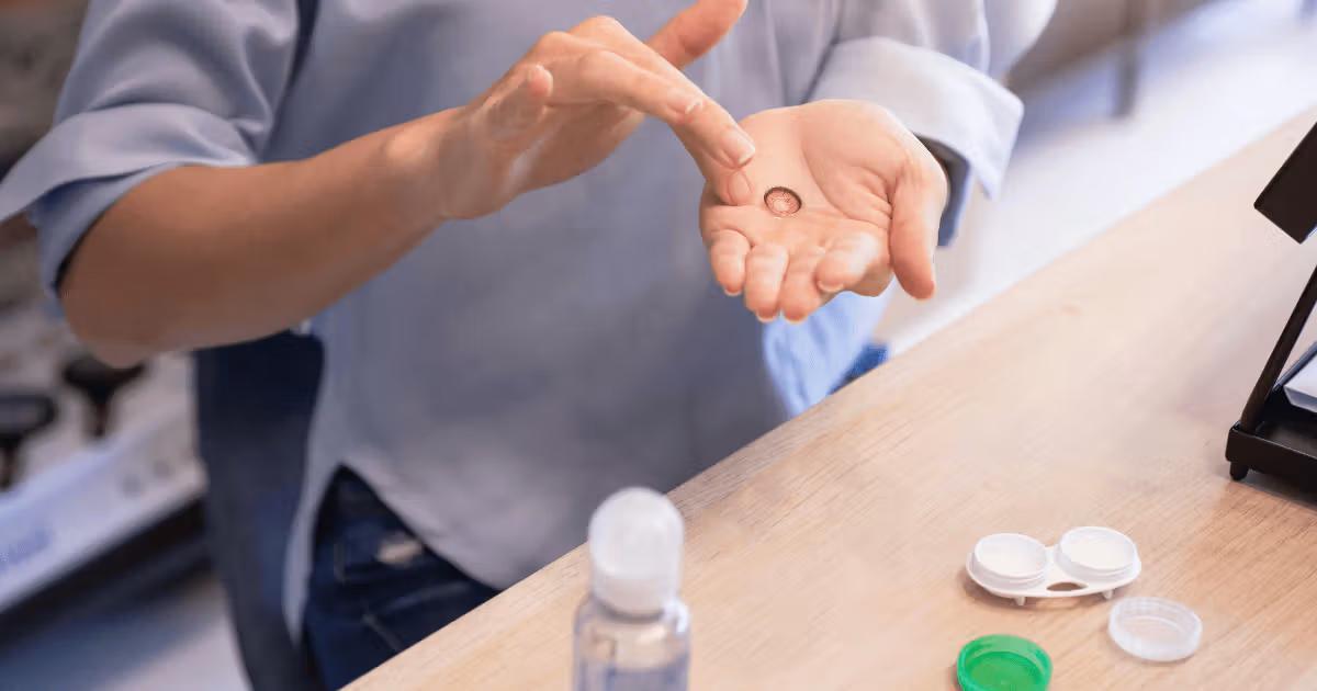 Person cleaning contact lenses with contact lens solution