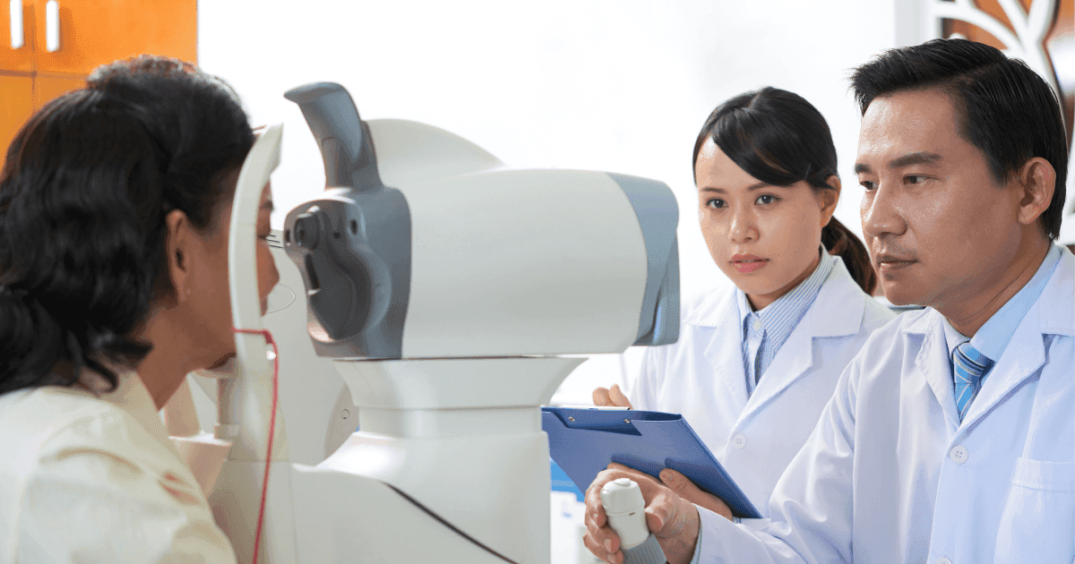 Patient undergoing an eye examination with two eye care professionals for hyperopia assessment