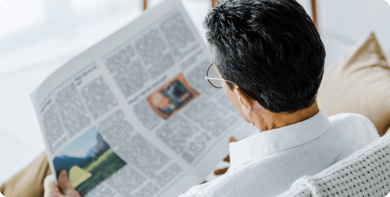 man reading newspaper with glasses for presbyopia management
