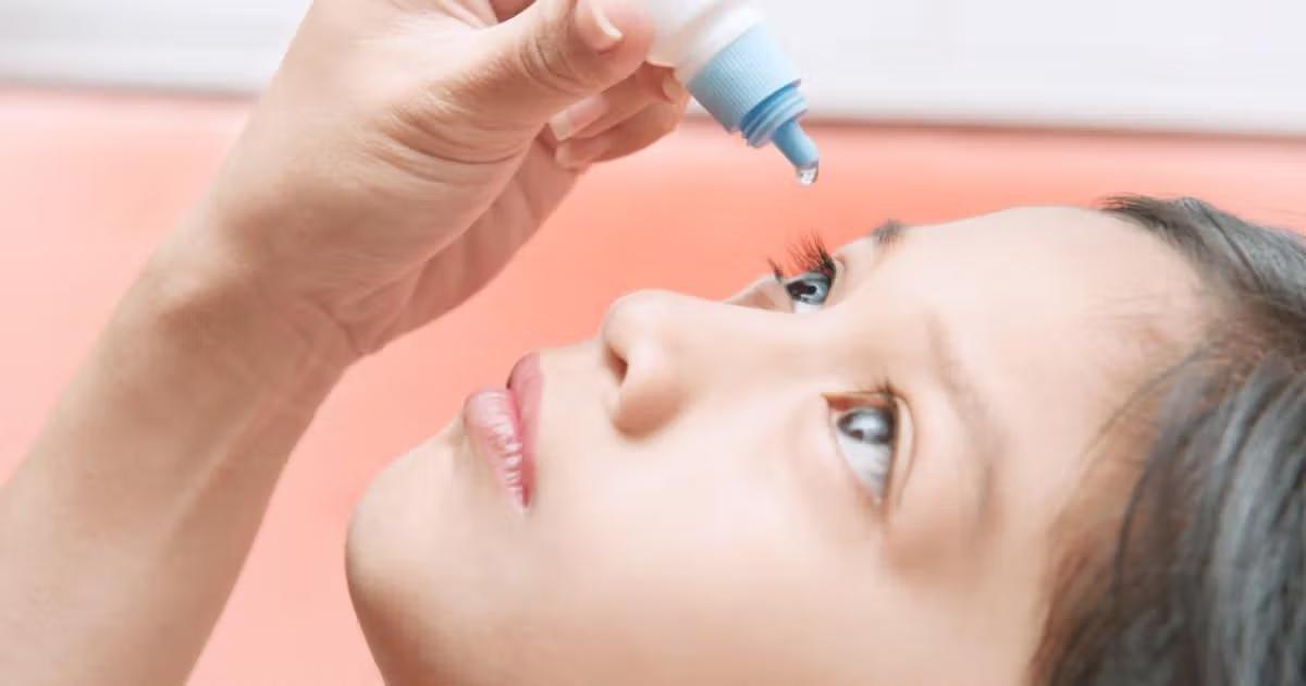 Child applying eye drops as part of myopia control treatment.