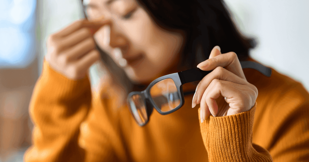 Woman holding glasses, representing eyeglasses as a common treatment option for astigmatism